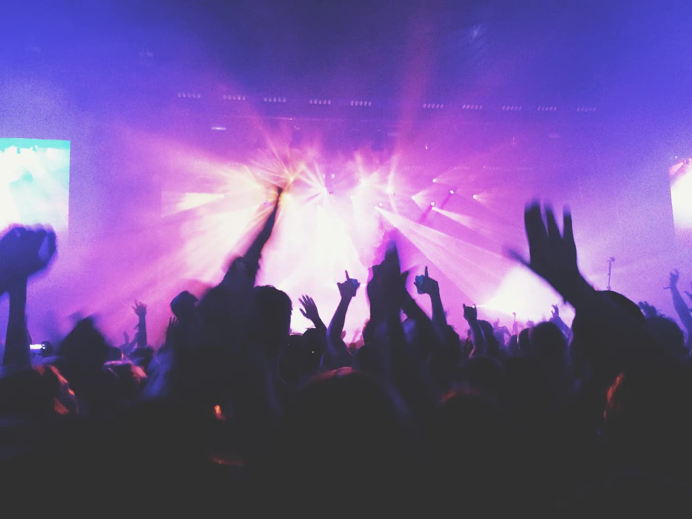 A crowd with hands raised at a live concert