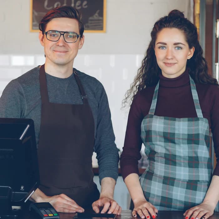 Two cafe owners behind their counter
